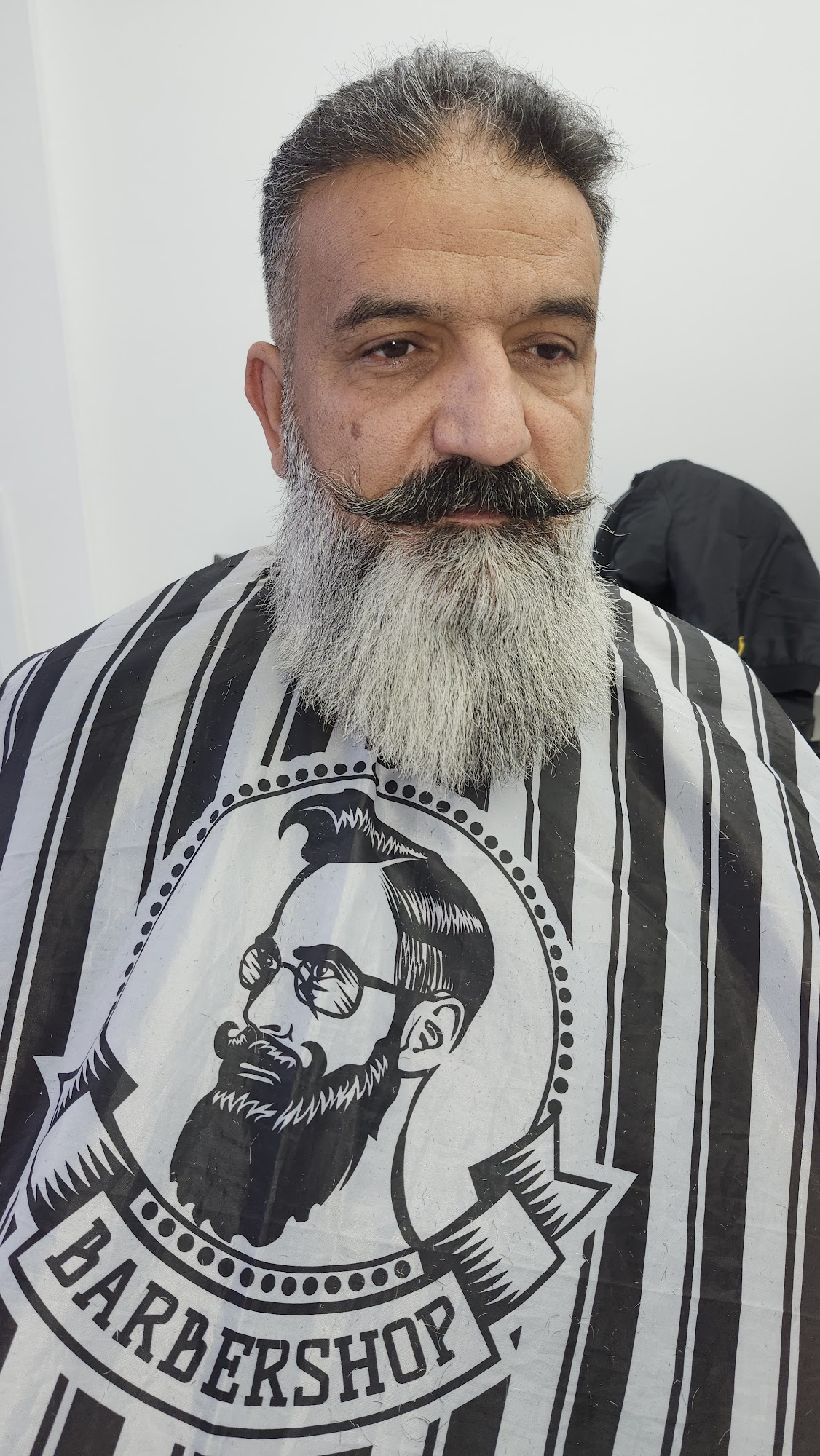 Beard trim in the branded cape at Kamal Barber Shop